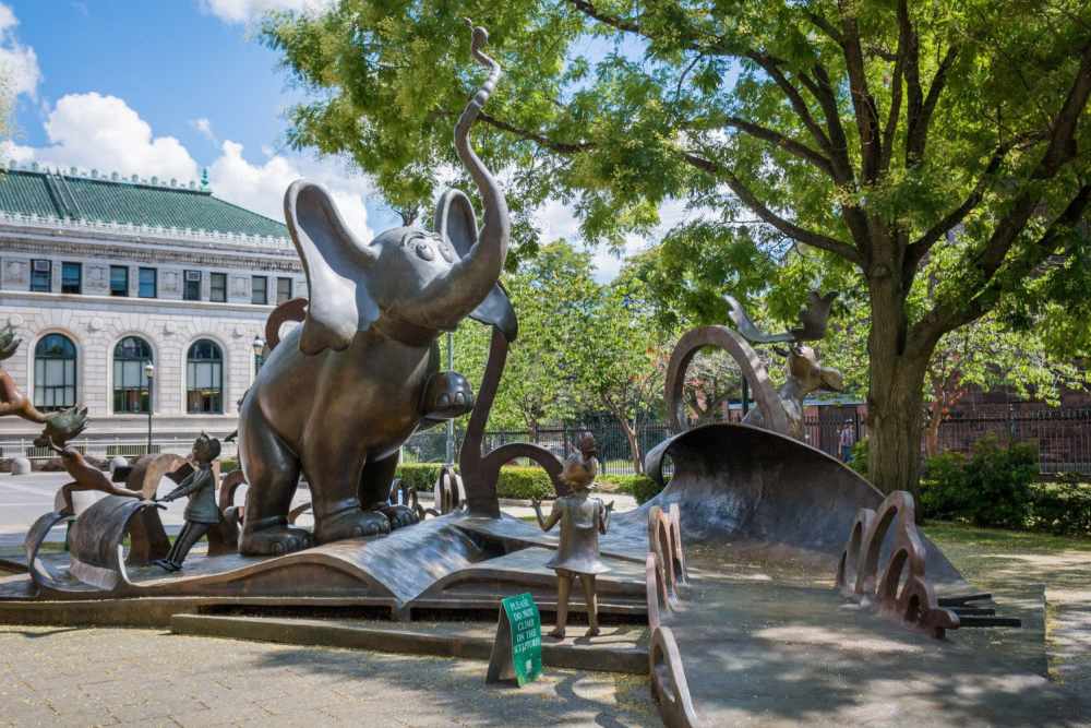 A whimsical bronze sculpture of an elephant and children playing in a park near Skyview Downtown in Springfield, Massachusetts