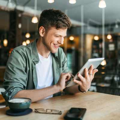 Resident using tablet at a cafe near 2202 Luann Place Apartments in Madison, Wisconsin