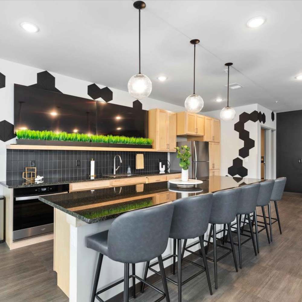 Community kitchen with stainless-steel appliances and breakfast countertop with barstool at Michigan Street Commons in Milwaukee, Wisconsin