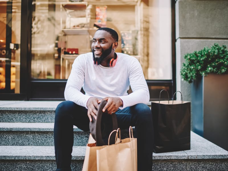 A man smiling and sitting on steps outside of a shop near The Gables in Ridgeland, Mississippi