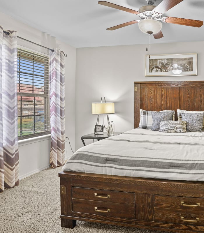 Chic bedroom with ceiling fan at Portofino Apartments in Wichita, Kansas