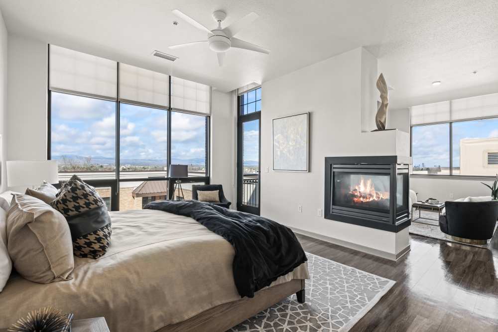 Modern bedroom with electric fireplace and sunlit windows at Kent Place Residences in Englewood,Colorado