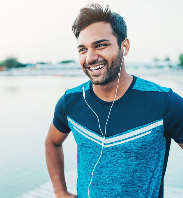 A man smiling by a body of water near The Courts of Avalon in Pikesville, Maryland