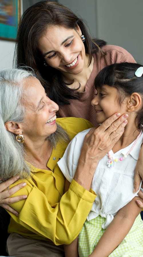 Grandmother, mother, and grandchild together at Pillars Senior Living in Lakeville, Minnesota