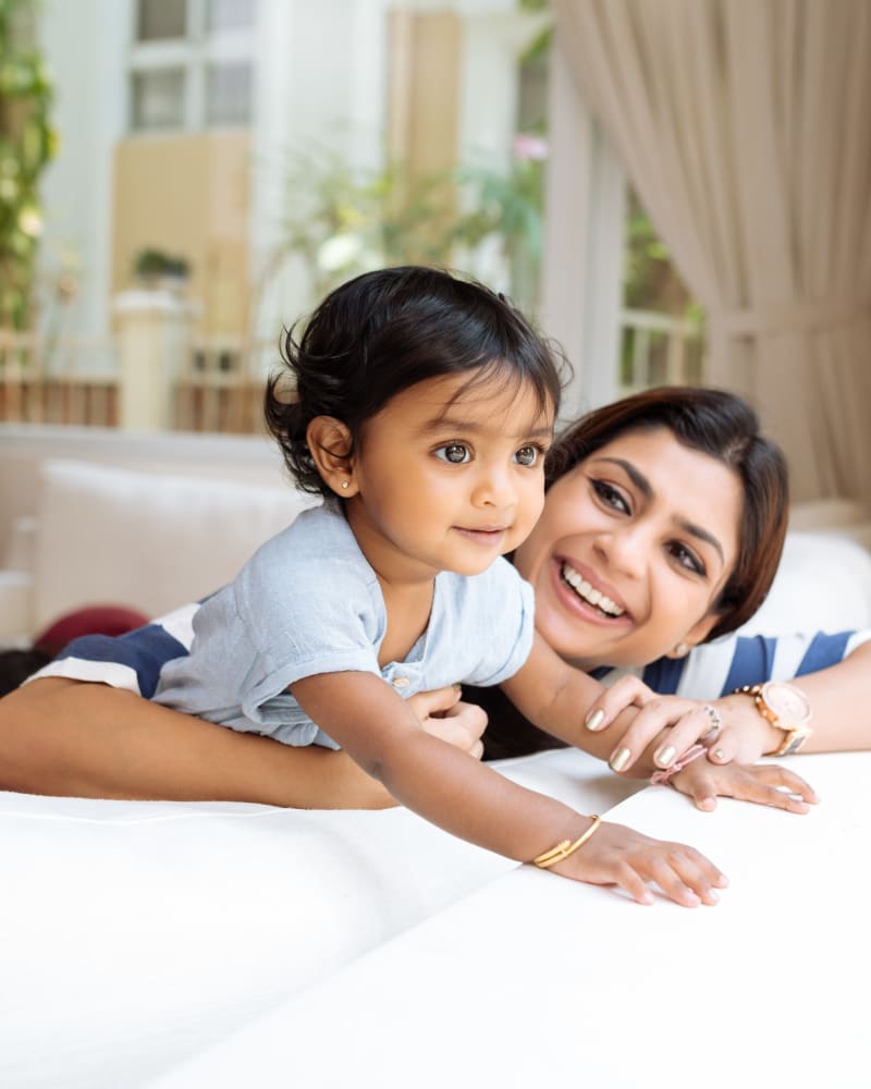 A happy mother holding her child on their couch at Residence at Riverside in Austell, Georgia