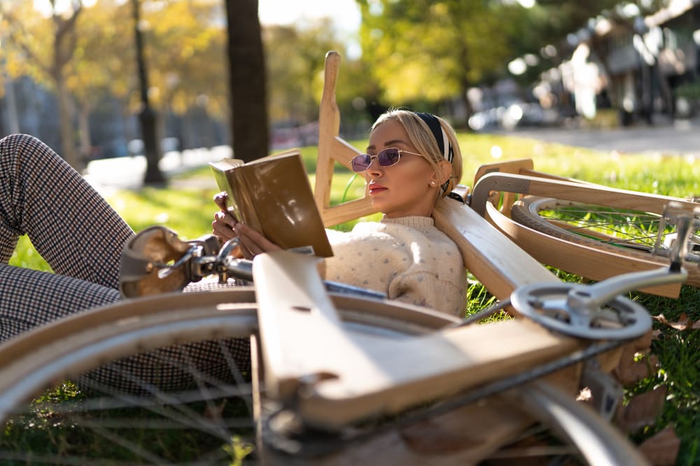 Resident relaxing with her bike in the grass near The Millton in Redwood City, California