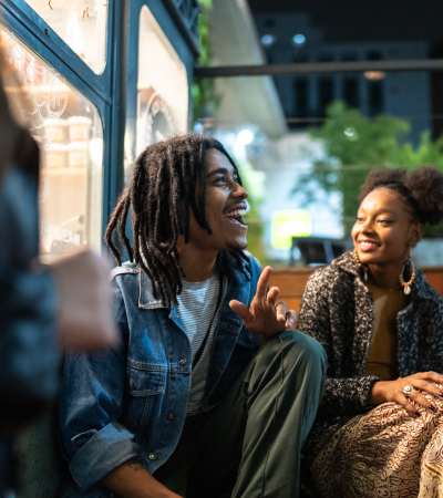 Man with dreadlocks laughing with a woman nearby near Brush Factory Lofts in Philadelphia, Pennsylvania