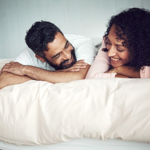 A happy couple laying down on bed at Lyman Park in Quantico, Virginia