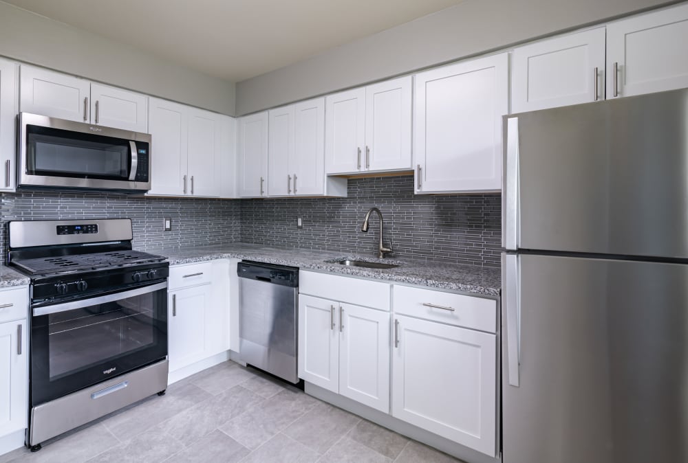 Upgraded kitchen with white cabinets, stainless appliances, and granite countertops at Tanglewood Terrace Apartment Homes in Piscataway, New Jersey