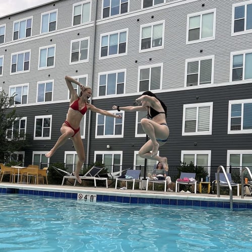 Residents enjoying community pool at The Banks apartments in Coralville, Iowa