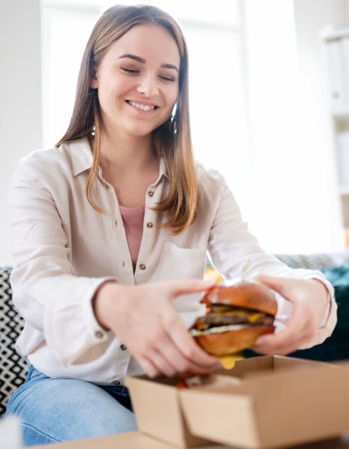 Resident treating herself to a tasty burger between classes in her home at River Pointe in Carrollton, Georgia