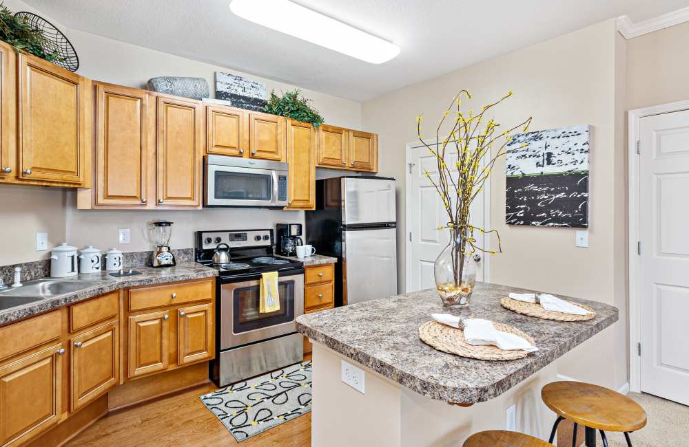 Open kitchen with dishwasher and hard wood-style flooring at The Crossings At Nine Mile Road in Pensacola, Florida