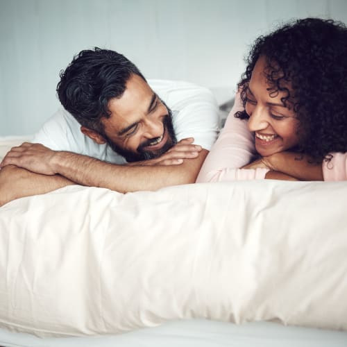 A happy couple laying on the bed at Prospect View in Santee, California