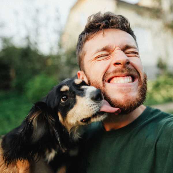 Man smiling with dog at Valley Brook Townhomes in Rochester, New York