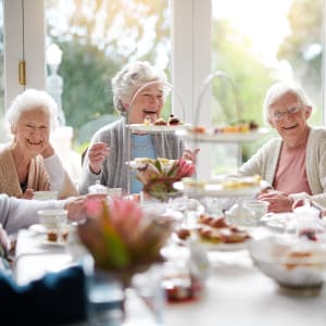 Residents laughing over breakfast at a Arcadia Communities community