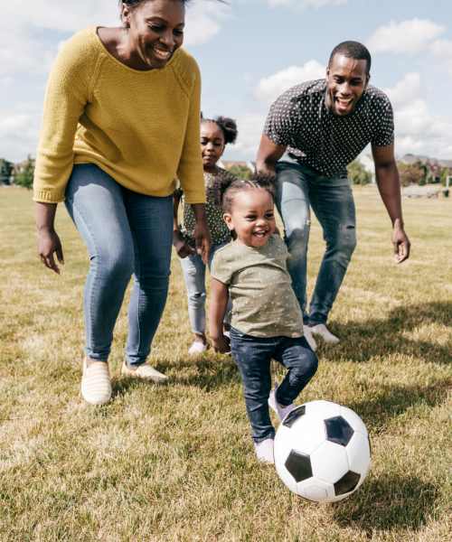 Family playing soccer on grassy field near Clarkwood Greens in Warrensville Heights, Ohio