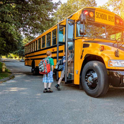 Children joyfully running towards school bus near Greentree in Indianapolis, Indiana