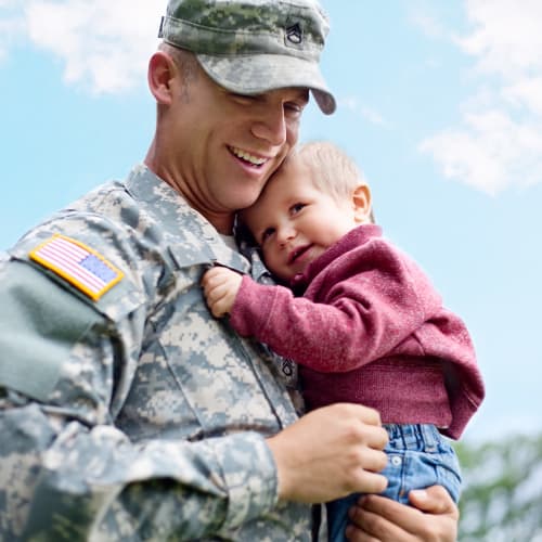 A resident wearing a uniform and his son at Madigan in Joint Base Lewis McChord, Washington