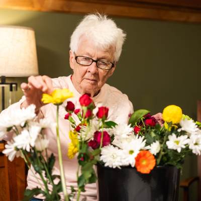Resident arranging flowers at Meadows on Fairview in Wyoming, Minnesota
