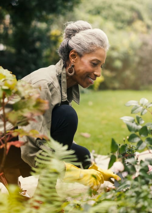 An elderly woman doing gardening at The Pillars of Prospect Park in Minneapolis, Minnesota