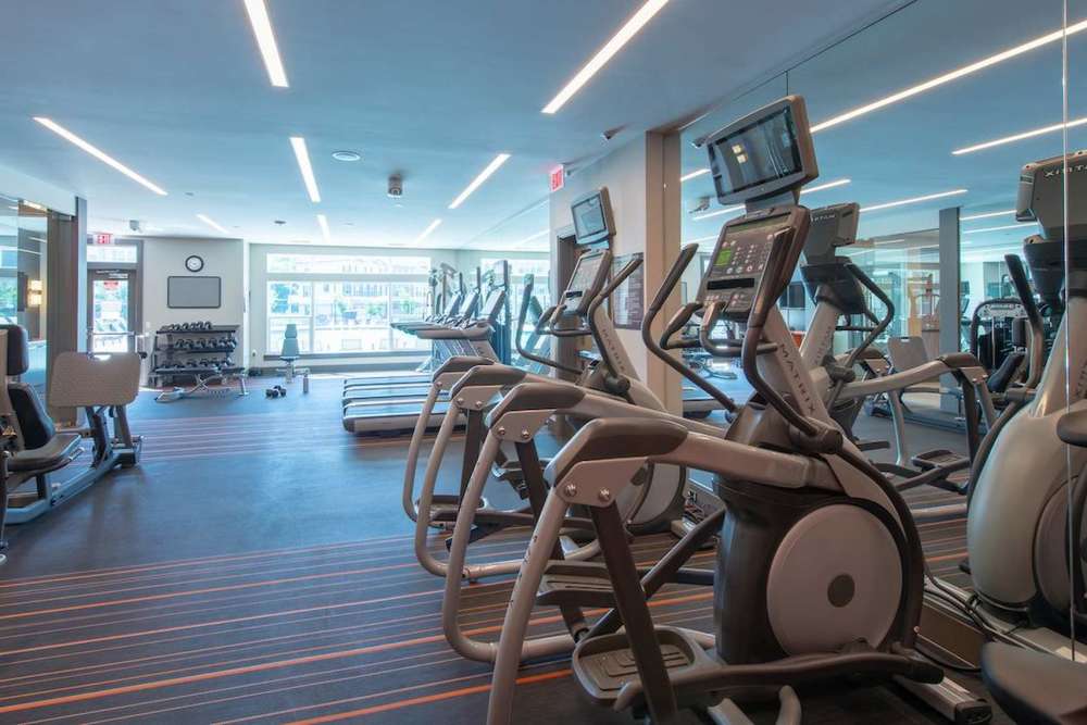 Well-equipped fitness center with treadmills and weight-lifting machines at The Elms at Signal Hill Station in Manassas, Virginia