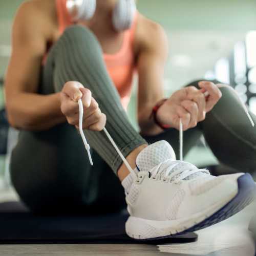 Person tying shoelaces on a sneaker at Avia Lofts at Maple Road in Amherst, New York