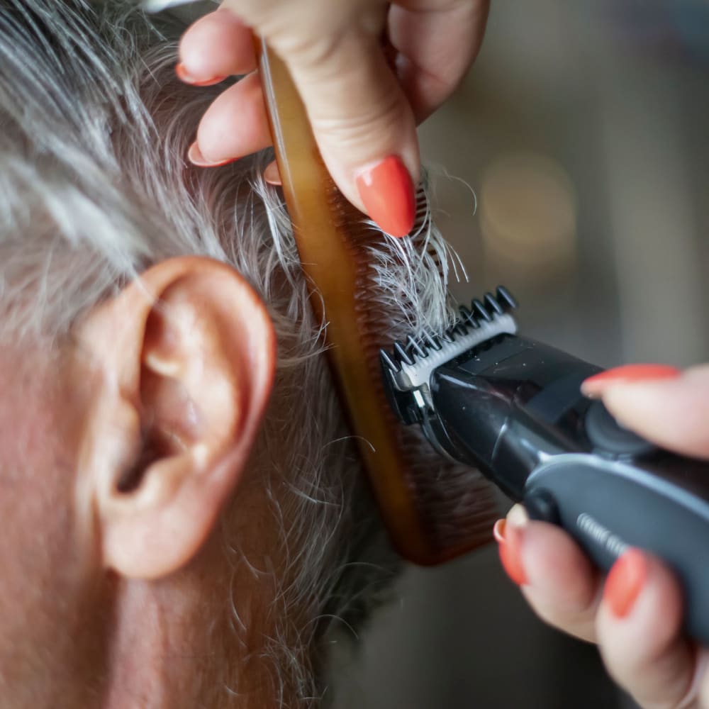A resident getting a haircut at Garden Square of Greeley Memory Care in Greeley, Colorado