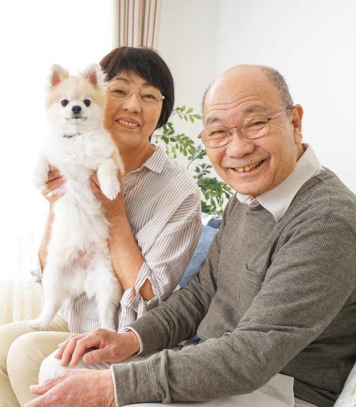 A resident couple holding their dog at The Sanctuary at Brooklyn Center in Brooklyn Center, Minnesota