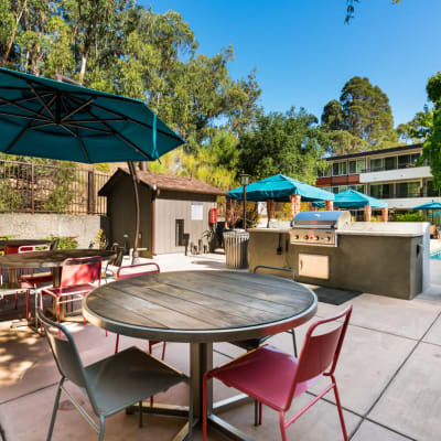 Overhead view of an umbrella partially shading a table and chairs at Sofi Belmont Glen in Belmont, California