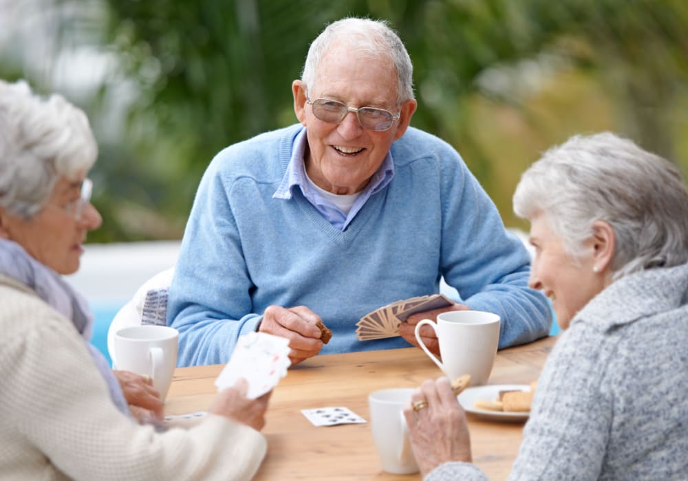 Senior living Resident playing cards with other residents at Clayton Oaks Living in Richmond, Texas