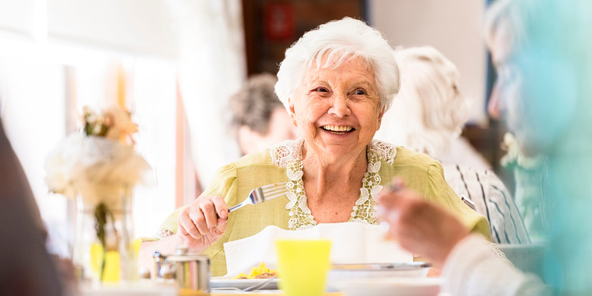 Woman in yellow shirt dining in a dining room