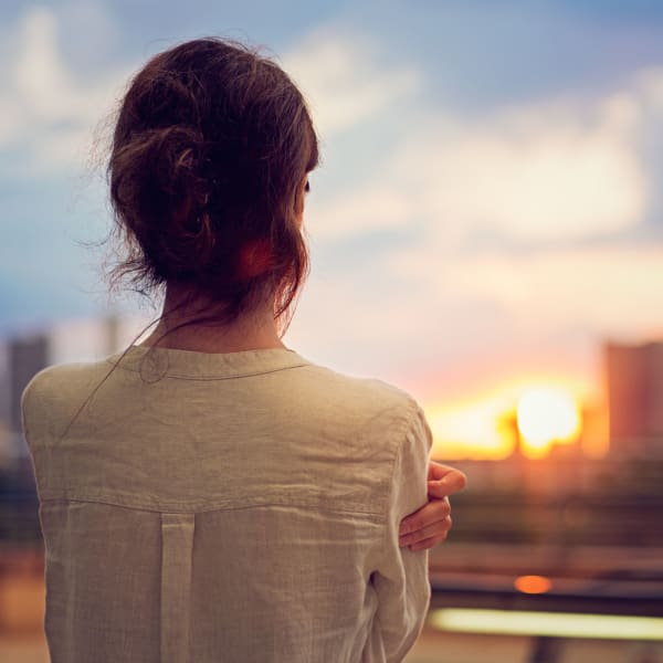 A woman looking at the city skyline near NextGen Properties in Costa Mesa, California