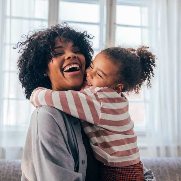 resident smiling with their kid at Attain at Chic’s Beach in Virginia Beach, Virginia