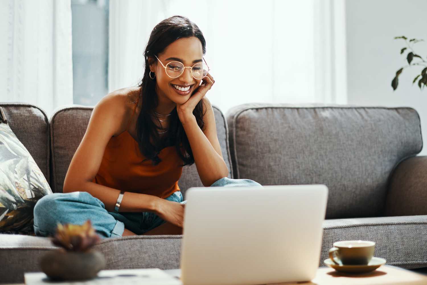 Resident watching her laptop in her apartment at The Trail Lakes in Fort Worth, Texas