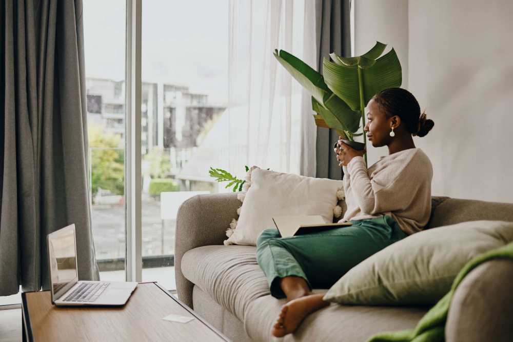 A Resident woman in a living room with plush carpeting at Smallwood Gardens in Waldorf, Maryland