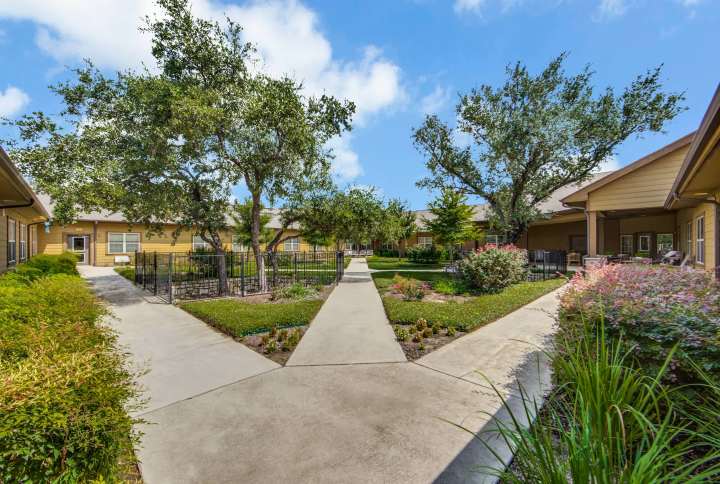Peaceful courtyard with walking paths and gardens at The Landing at Stone Oak in San Antonio, TX, offering a relaxing outdoor space.