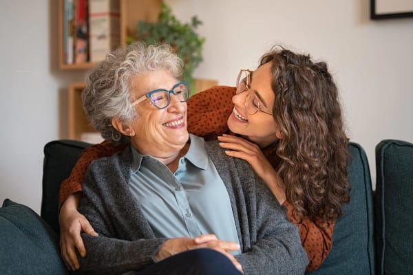 Woman embracing resident from behind at Village on the Park Steeplechase in Houston, Texas