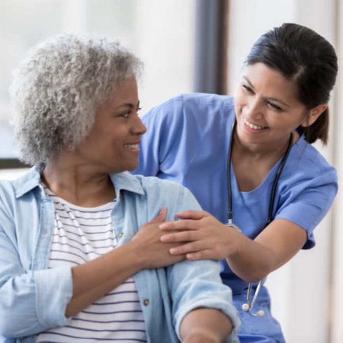 A nurse holding a resident's hand at Harmony at Mt. Juliet in Mt Juliet, Tennessee