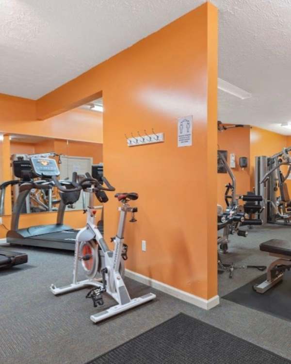 Brightly colored fitness center with cardio equipment and weight machines, inviting workout space at Castle Ridge Apartments in Pittsburgh, Pennsylvania