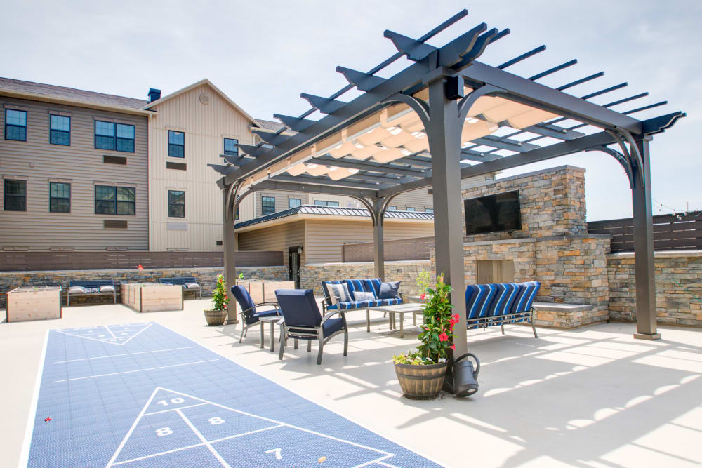 Outdoor large patio with shade awning, seating, fireplace, and tables at The Pinnacle at Plymouth Meeting in Plymouth Meeting, Pennsylvania