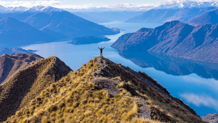 A person on top of a mountain near lakes
