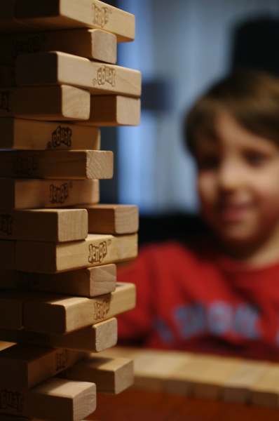 a child looks on at a stack of jenga blocks