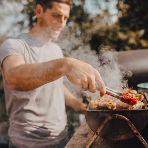 A resident grilling food in a backyard at Gela Point in Virginia Beach, Virginia