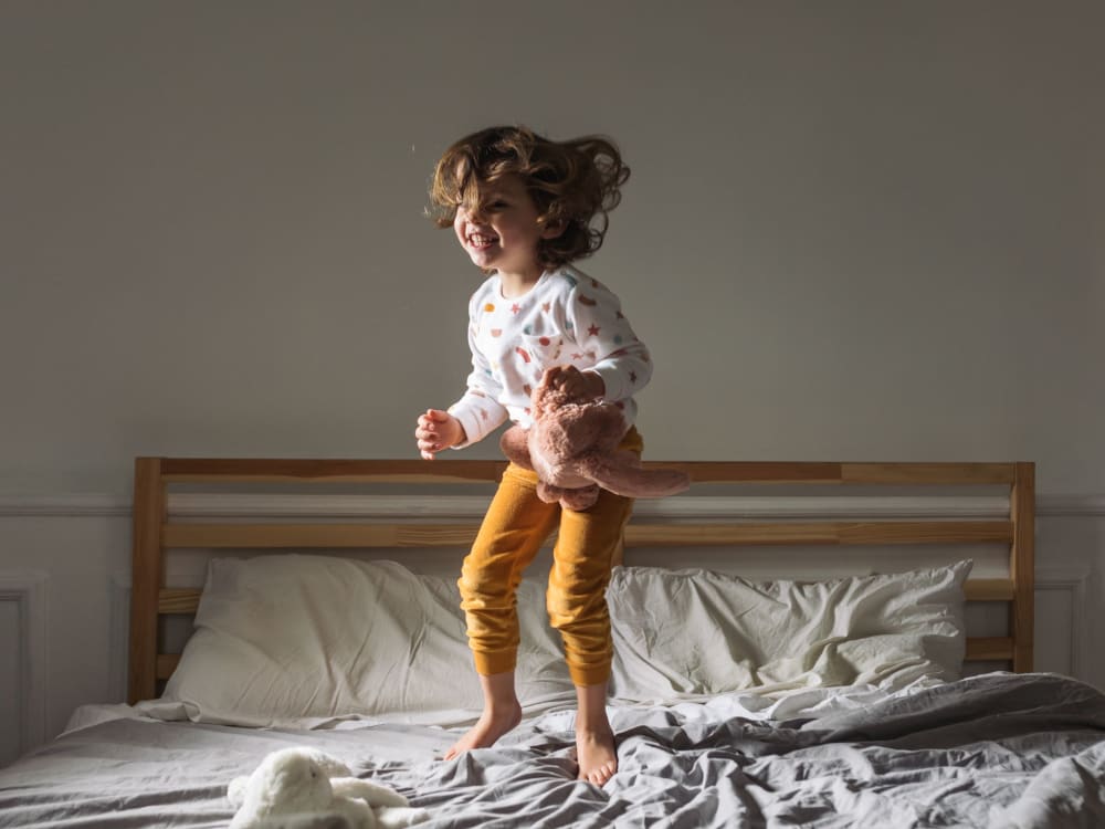 Kid jumping on the bed at Montecito Apartments in Santa Clara, California