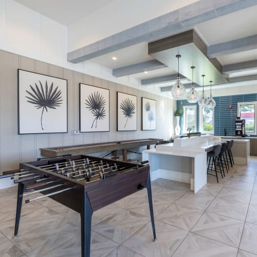 Seating and games in the community lounge at Indigo Champions Ridge in Davenport, Florida