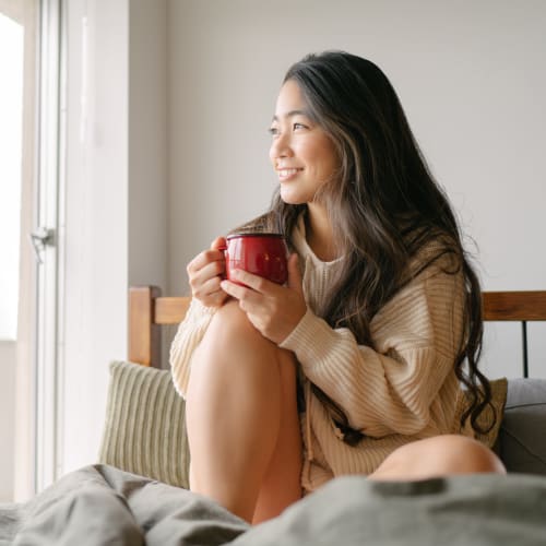 A resident relaxing on a bed in a home at Kansas City in Belton, Missouri