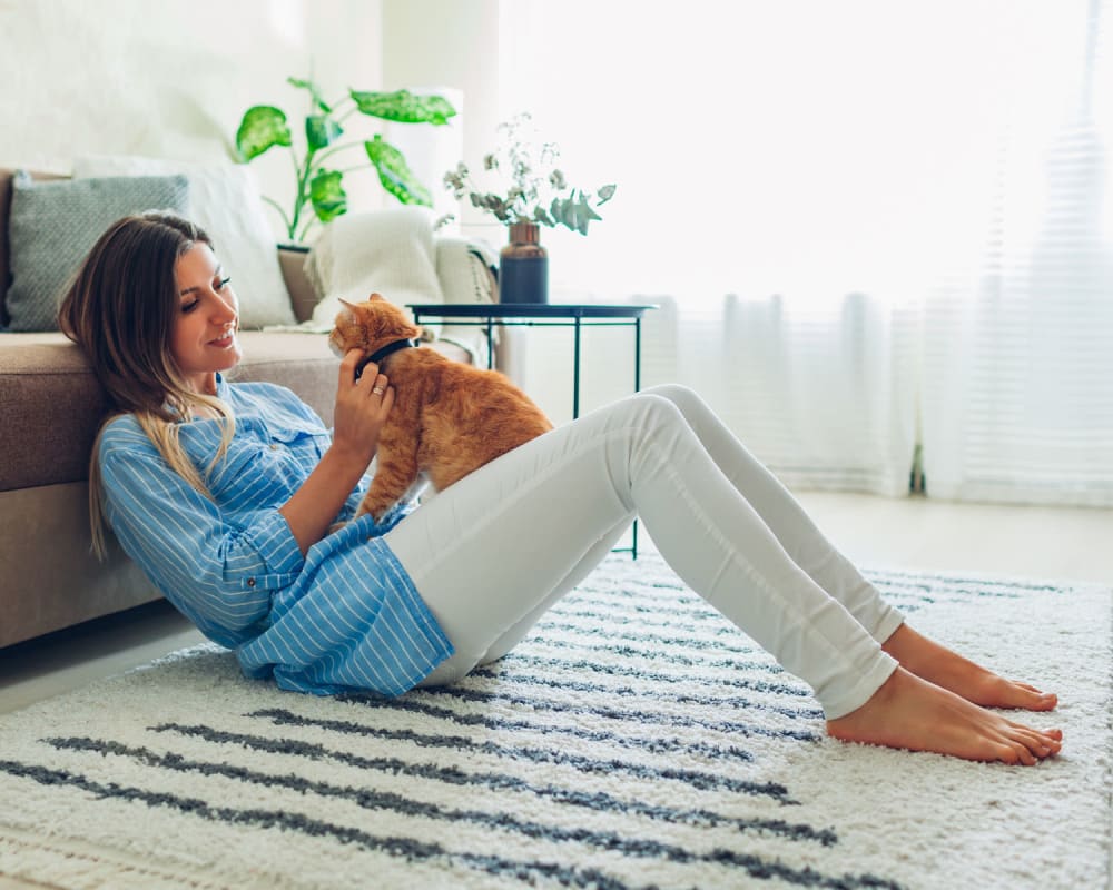 Happy kitten and her owner relaxing in the living area of their apartment at Oaks Hiawatha Station in Minneapolis, Minnesota