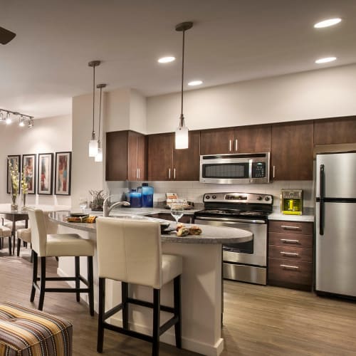 Gourmet kitchen with an island and granite countertops in a model home at Redstone at SanTan Village in Gilbert, Arizona