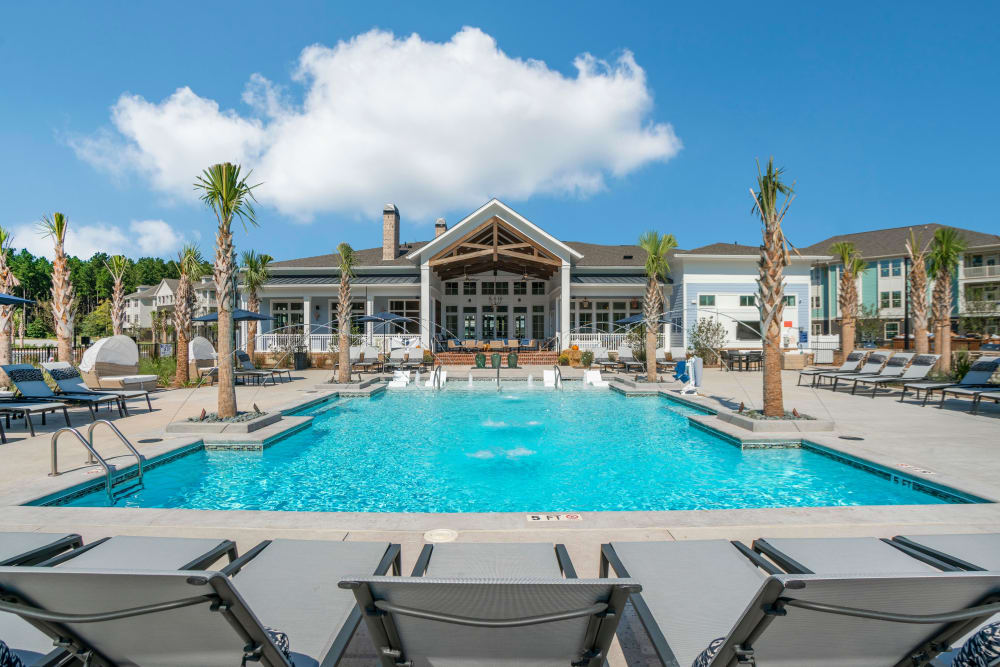 Fluffy white clouds on a beautiful day at the swimming pool area of a multifamily community by Electra America in Lake Park, Florida