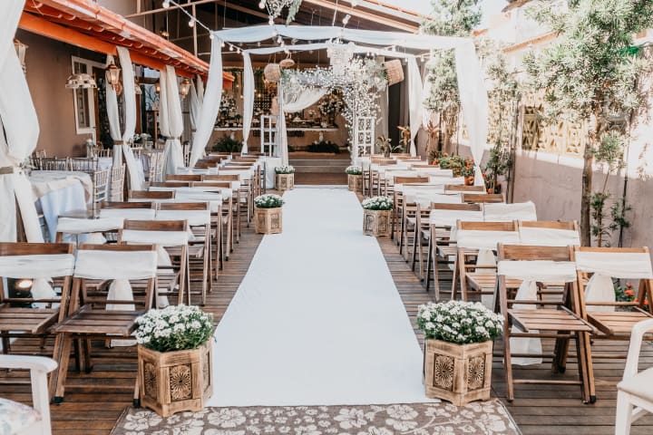 wedding aisle with chairs and a white fabric down the aisle